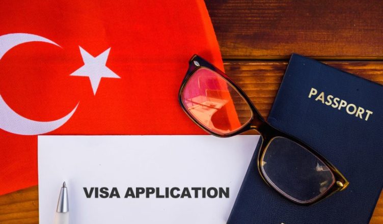 Flag of Turkey, visa application Form and passport on a table.